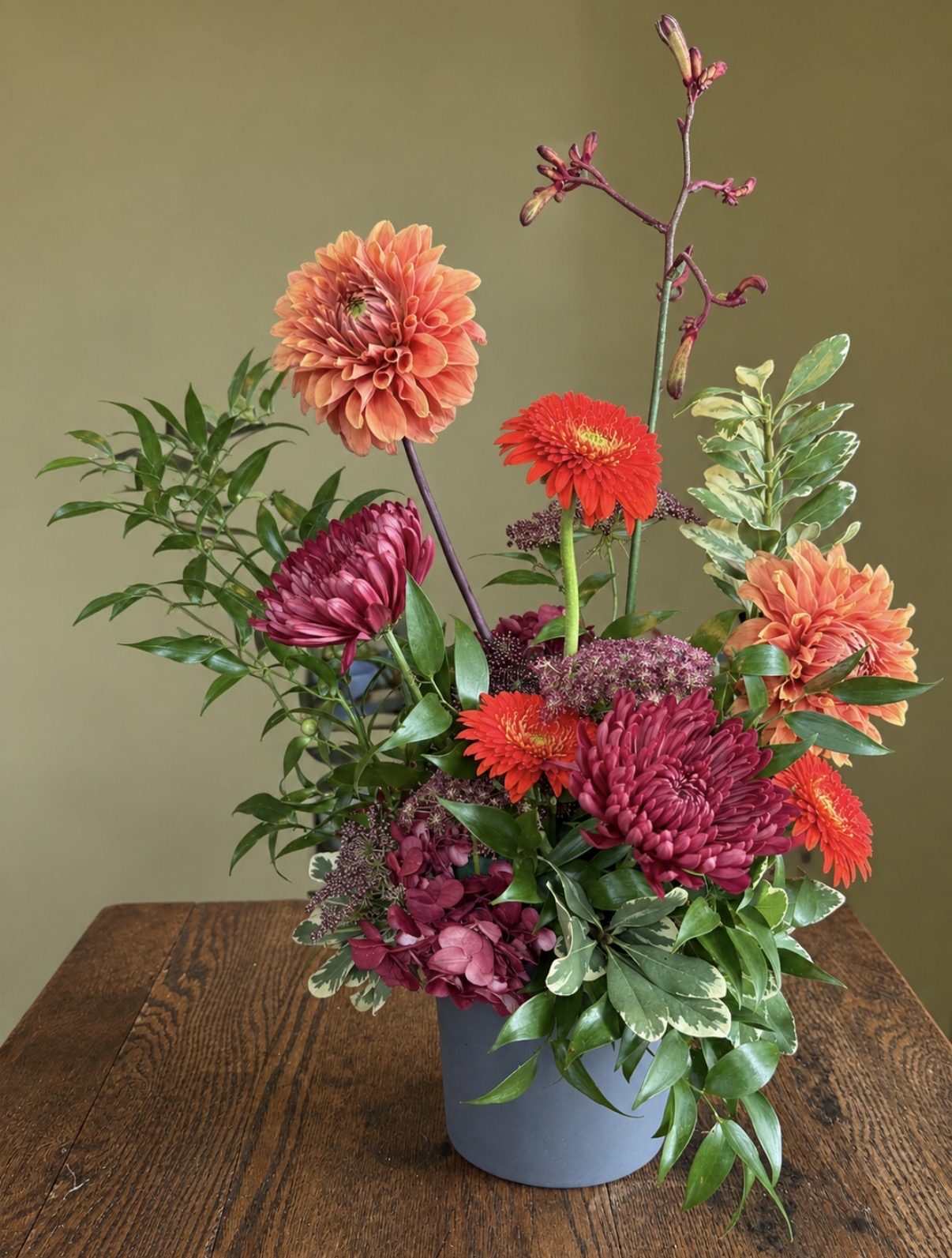 Orange and burgundy dahlia and chrysanthemum arrangement
