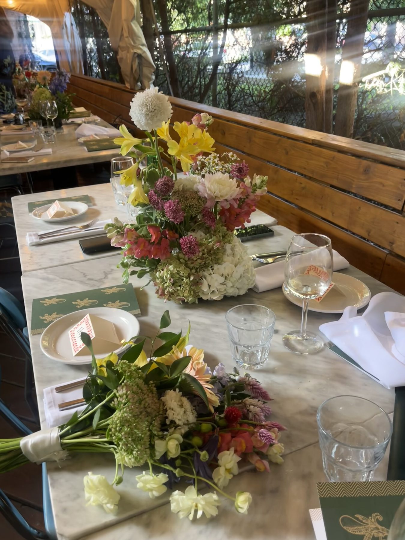 Wedding table setting with a hydrangea and alstroemeria centerpiece and hand-tied bouquet