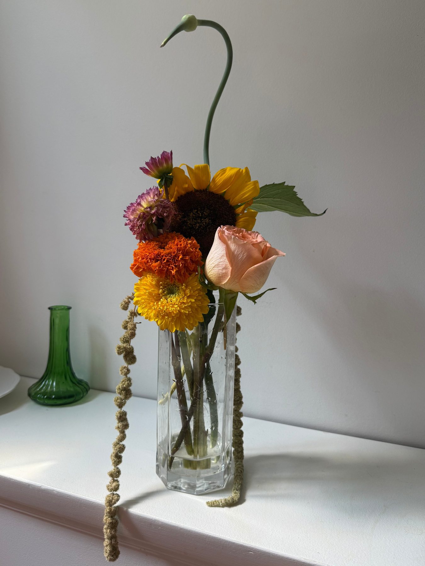 Sunflower, dahlia and rose arrangement in a tall glass vase